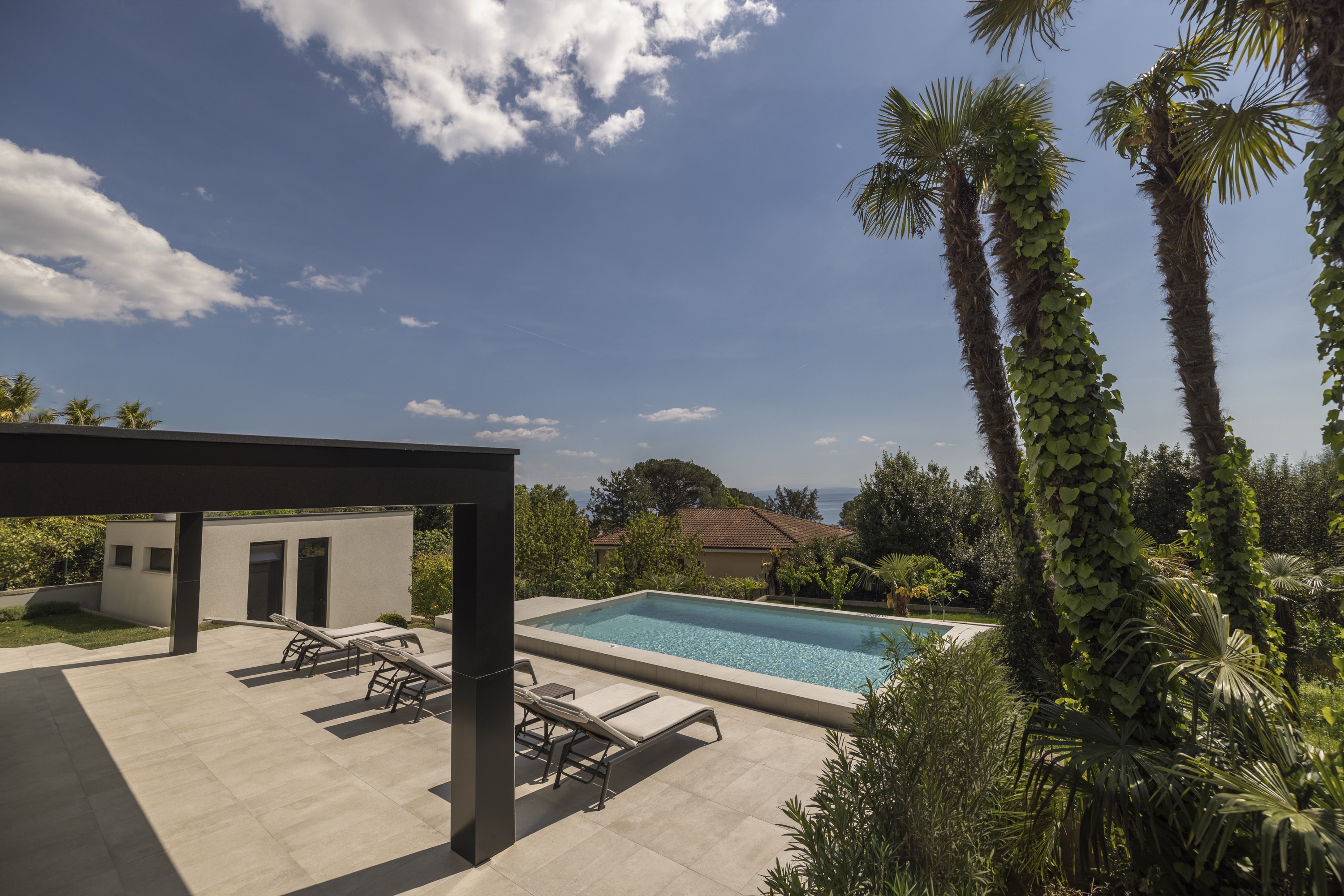 Villa exterior with pool and loungers